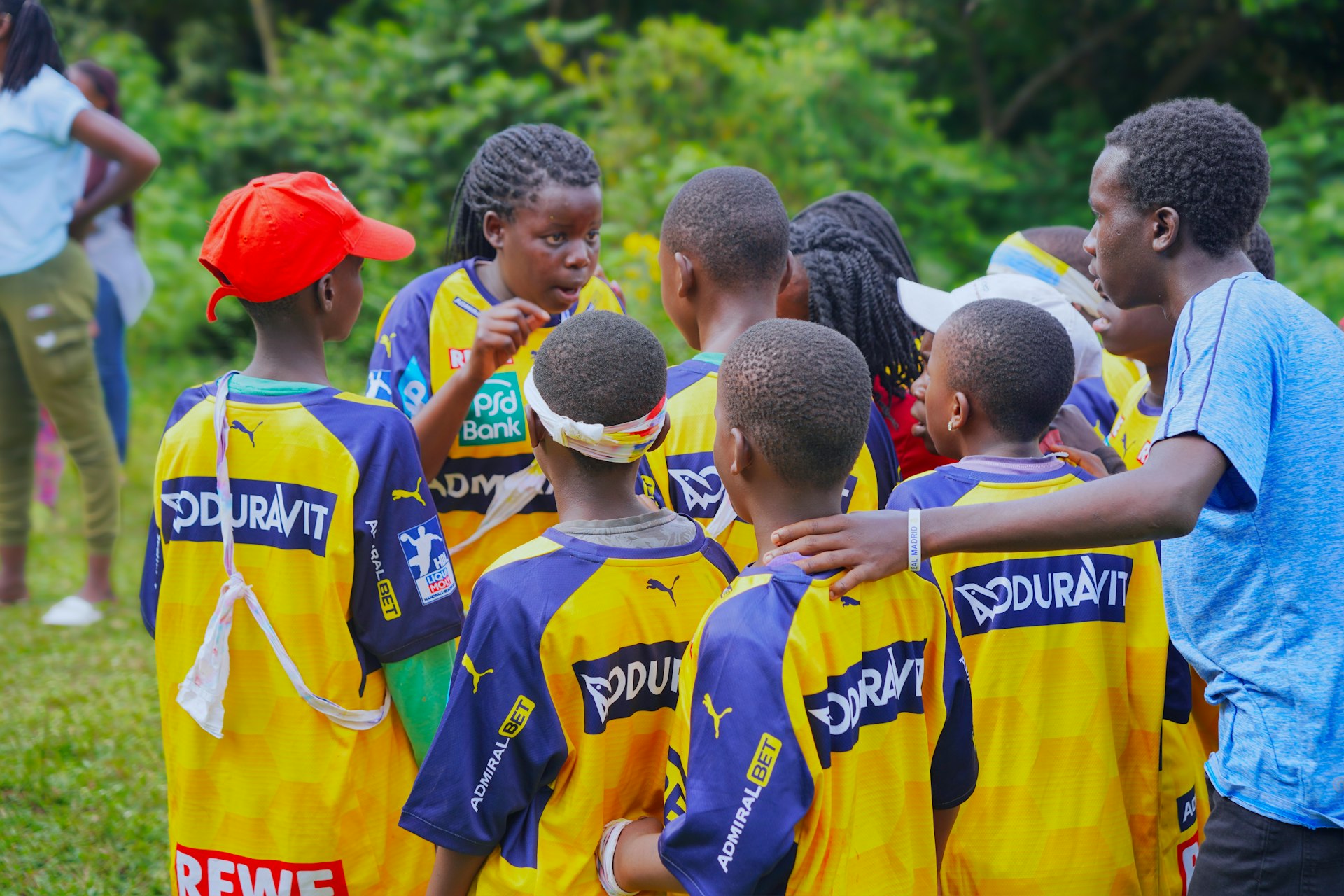 A soccer team huddles together for a pep talk.